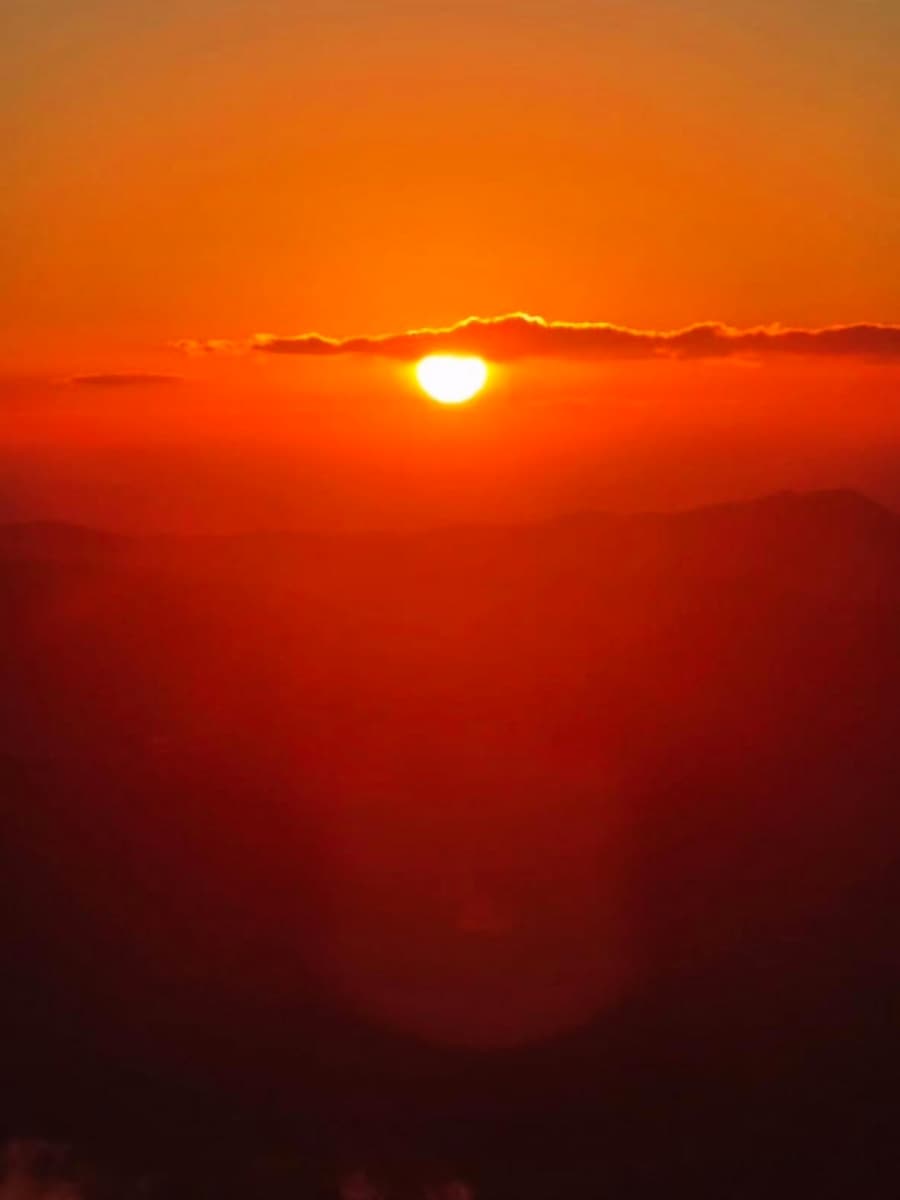 Sol nascendo no horizonte, com o céu todo laranja